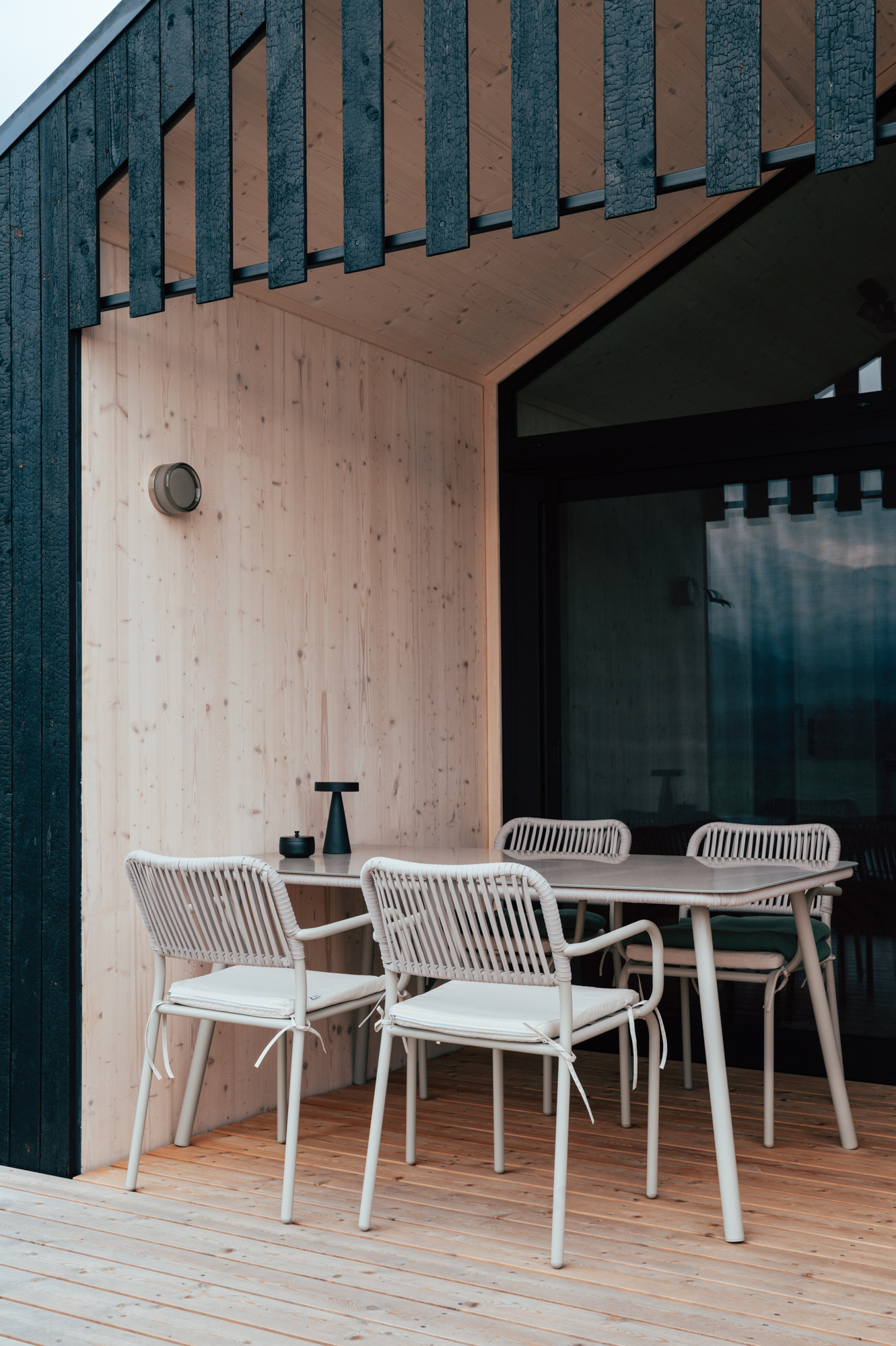 Detailansicht der Terrasse eines Hapfn Tiny House: Außenfassade mit senkrechter Holzverschalung in Vulcano Black von Mareiner.